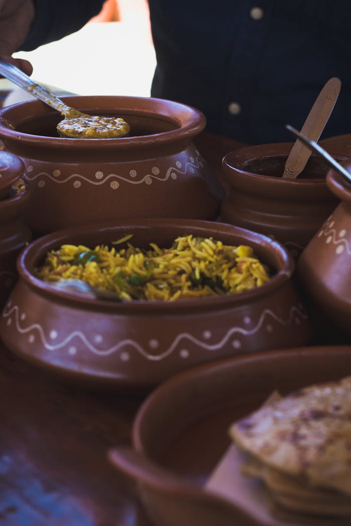 Colorful Indian dishes beautifully presented in clay pots, highlighting traditional cuisine.