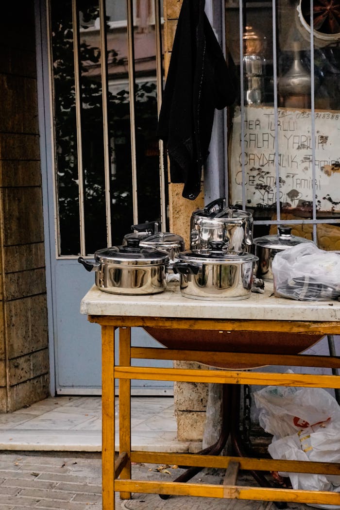 Stainless steel pots and pans displayed on a street in Turkey, offering a glimpse of local commerce.