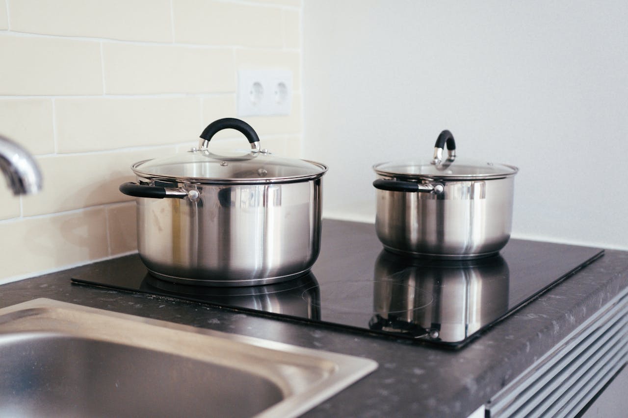 Contemporary kitchen setup with stainless steel pots on an induction stove.